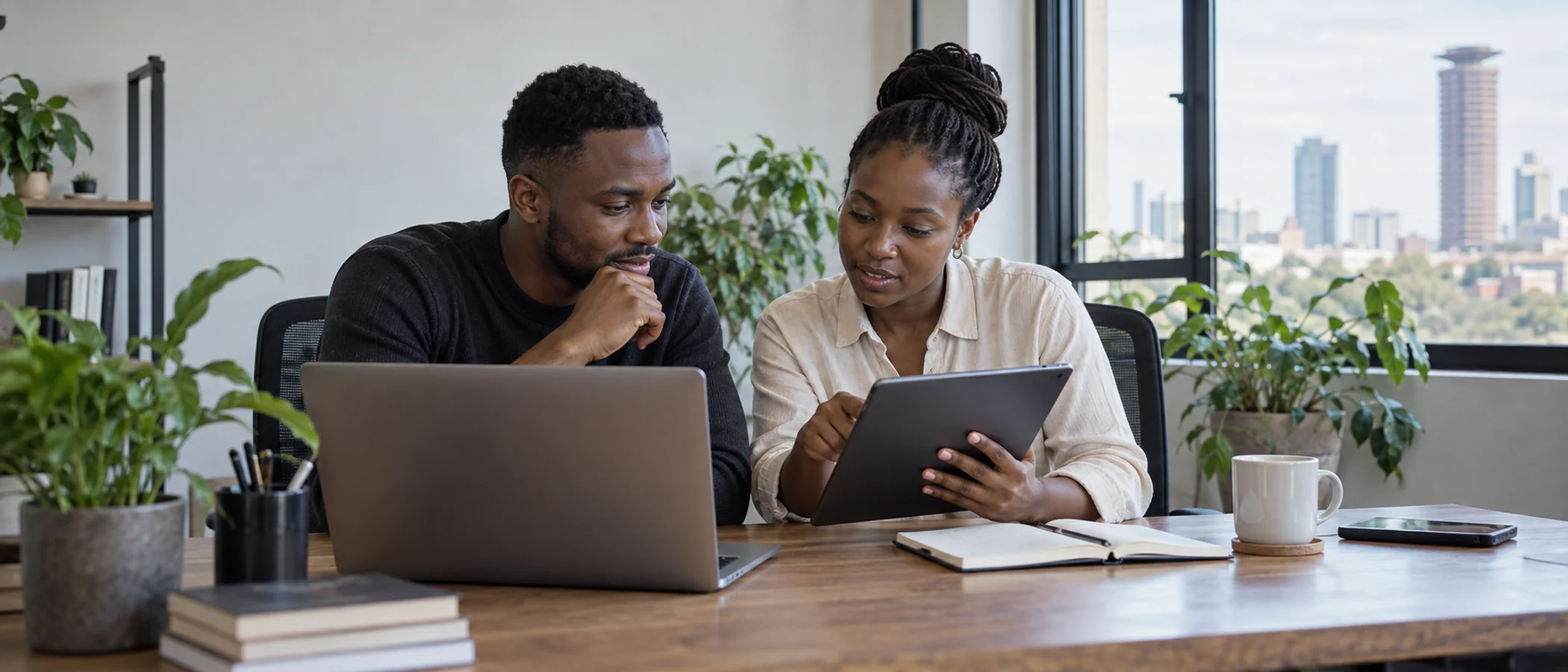 Two Kenyan developers reviewing their project after the hackathon