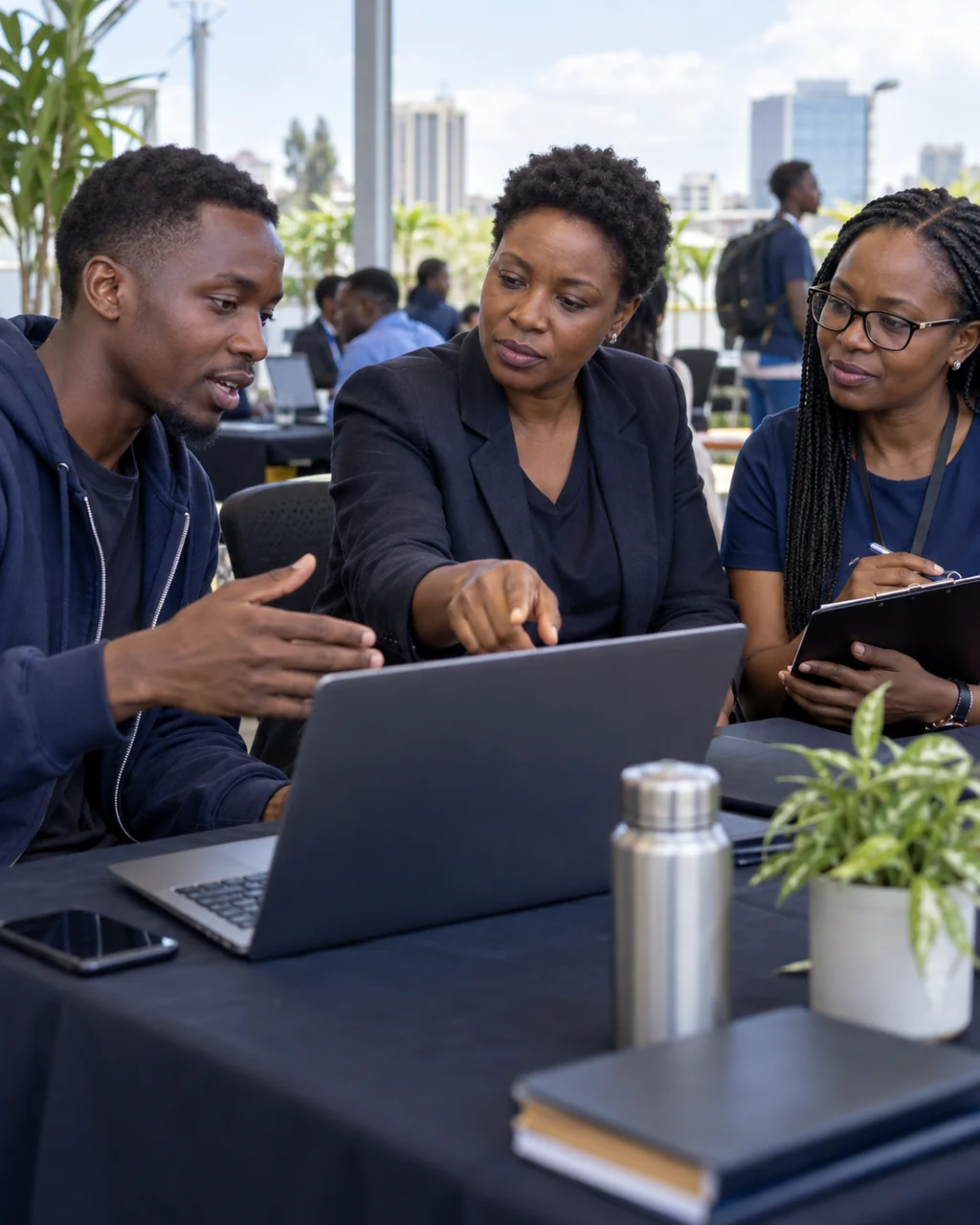 A Kenyan developer demonstrating his project to two hackathon judges